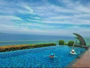 a swimming pool with a view of the ocean at Sea View Studio in Pattaya South