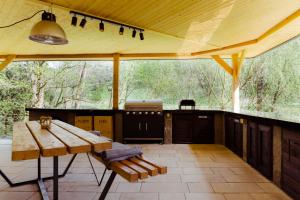 a patio with a wooden table and a bench at Tiny house Malý gurmán in Rohozná