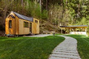 a cabin in the woods with a walkway at Tiny house Malý gurmán in Rohozná