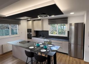 Una cocina con una mesa con sillas y un refrigerador. en Catalunya Casas Stunning Villa with private pool 33 km to Barcelona, en Senmenat