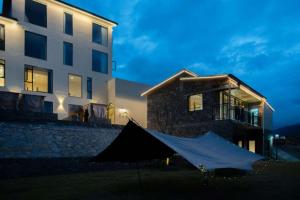 a tent in front of a building at night at Endless Summer Cloudscape Hot Springs Siguniang Mountain in Mount Siguniang