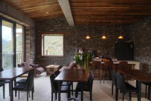 a living room with wooden ceilings and tables and chairs at Endless Summer Cloudscape Hot Springs Siguniang Mountain in Mount Siguniang