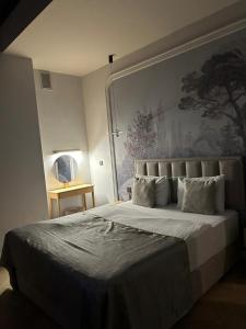 a bedroom with a large bed with a painting on the wall at Luxury City Apartments in Baku +41 photos