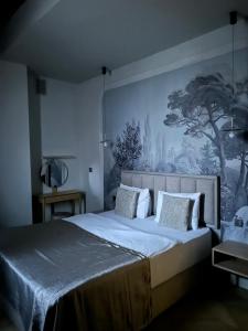 a bedroom with a large bed with a painting on the wall at Luxury City Apartments in Baku