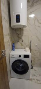een wasmachine in de hoek van een badkamer bij Apartments Dubrava 6 in Zagreb