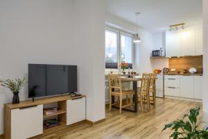 a kitchen and living room with a flat screen tv at Apartamenty Słoneczna in Tylicz