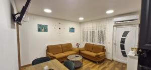 een woonkamer met 2 stoelen en een bank bij Apartments Dubrava 6 in Zagreb