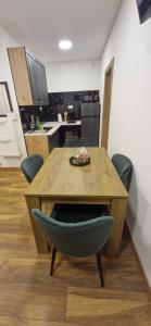 een keuken met een houten tafel met stoelen en een tafel en een tafel bij Apartments Dubrava 6 in Zagreb +7 foto's