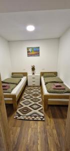 een kamer met 2 bedden en een tapijt bij Apartments Dubrava 6 in Zagreb