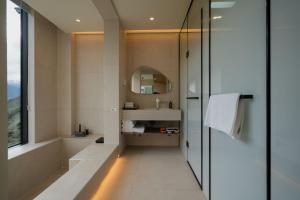 a bathroom with a tub and a sink and a mirror at Endless Summer Cloudscape Hot Springs Siguniang Mountain in Mount Siguniang +123 photos
