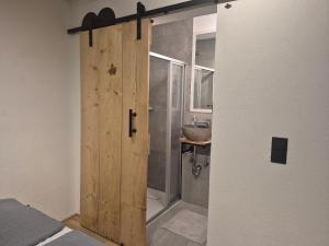 una puerta de madera en un baño con lavabo en Ferienhaus Michael, en Scharnitz 45 fotos más