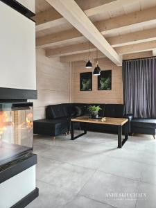 a living room with a couch and a table at Anielskie chaty - domki z widokiem na góry in Sablówka +74 photos