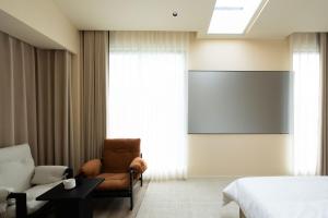 a room with a bed and a chair and a projection screen at Endless Summer Cloudscape Hot Springs Siguniang Mountain in Mount Siguniang