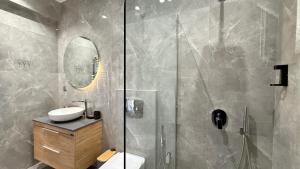 ein Badezimmer mit Dusche, Waschbecken und Toilette in der Unterkunft SKY 5 Luxury Apartment in Kalamata + 6 Fotos