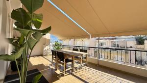 ein Balkon mit Tisch und Stühlen und einer Pflanze in der Unterkunft SKY 5 Luxury Apartment in Kalamata