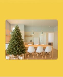 Un árbol de Navidad en un comedor con sillas blancas. en CHRISTMAS PROMO - Elegant Apartments NEW, en Durrës