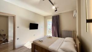 ein Schlafzimmer mit einem Bett und einem Fernseher an der Wand in der Unterkunft SKY 5 Luxury Apartment in Kalamata