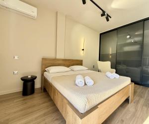 ein Schlafzimmer mit einem Bett mit weißen Handtüchern darauf in der Unterkunft SKY 5 Luxury Apartment in Kalamata