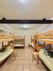 a room with three bunk beds and two stools at The Farmyard at Doddington in Doddington