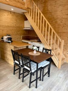 ein Tisch und Stühle in einer Küche mit einer Treppe in der Unterkunft Chalet Muguet, spa privatif, 4p in Rochesson