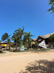 a small sail boat on a beach with palm trees at Central Flats Jeri in Jericoacoara
