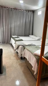 a row of beds in a room with curtains at Central Flats Jeri in Jericoacoara