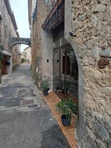 Love Room - Spa Privatif Gard في Saint-Michel-d'Euzet: مدخل إلى مبنى حجري به نباتات خزف