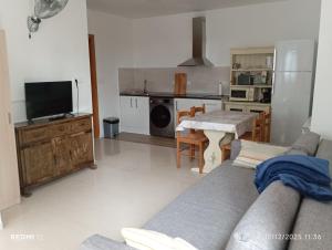 Una sala de estar con un sofá y una mesa y una cocina. en CASA el NOGAL, en Salas Bajas