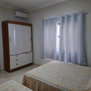 een slaapkamer met twee bedden, een ladekast en een raam bij Casa-Quiriri in Prado