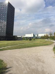 um edifício alto com um campo em frente a um edifício em Relais Villa Rosa em Pero