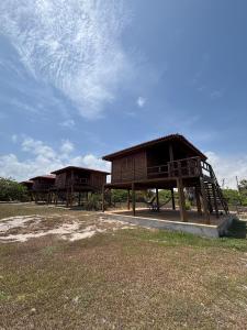 Duas pequenas casas de madeira estão situadas em um campo. em Canto do Mar - Atins - Lençóis Maranhenses em Atins