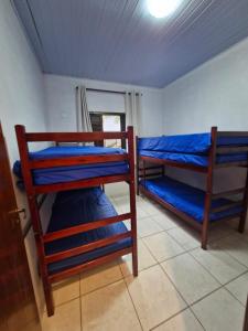 een kamer met 2 stapelbedden met blauwe lakens bij Condomínio Dell Mar in Bertioga +8 foto's