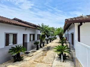een rij huizen met palmbomen langs een straat bij Condomínio Dell Mar in Bertioga