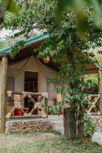 a house with a tent in front of it at Kipekee Zuri Camp in Ololaimutiek