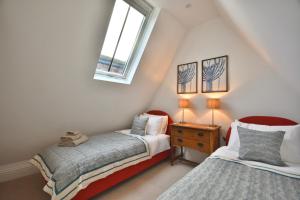 a bedroom with two beds and a window at 1 Purfleet Quay in King's Lynn