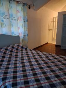 a bedroom with a bed with a checkered blanket at A few steps from the beach in Pereybere