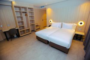 Un dormitorio con una gran cama blanca y estanterías en ARUBA BOUTIQUE HOTEL Casablanca, en Casablanca