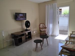 ein Wohnzimmer mit zwei Sesseln und einem Fernseher in der Unterkunft Potiribu in Ijuí
