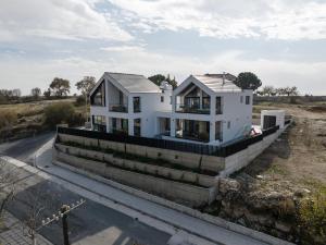 a white house sitting on the side of a road at Pamboo Ampelos House by Nomads in Statos and Ayios Photios