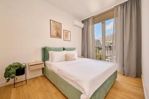 a bedroom with a bed and a large window at Skyline Sunset in Becici +120 photos