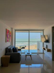 a living room with a couch and a view of the ocean at Artsy Oceanview Condo W Incredible Rooftop Pool in Cartagena de Indias