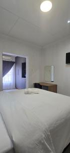 een groot wit bed in een witte kamer bij Good night guest house in Polokwane
