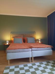 een slaapkamer met een bed met rode lakens en 2 tafels bij Im Stauberhaus in Kirchdorf an der Krems