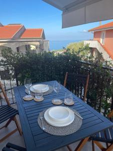 une table bleue avec des assiettes et des verres sur un balcon dans l'établissement Luxury Suite come al Four Seasons, à Paola