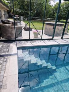 een glazen raam met uitzicht op een zwembad bij Villa - The Cozy Relax Home - Comfort Nature & Style in Beernem