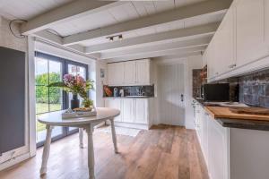 een keuken met een tafel met daarop een vaas met bloemen bij Villa - The Cozy Relax Home - Comfort Nature & Style in Beernem