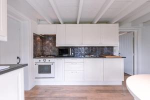 een witte keuken met witte kasten en apparaten bij Villa - The Cozy Relax Home - Comfort Nature & Style in Beernem