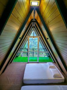 een bed in een kamer met een raam bij White Moon Cabin & Cottage in Ella