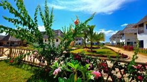 una casa con recinzione e fiori in un cortile di COCO JAMBO PARADISE Resort a Uroa