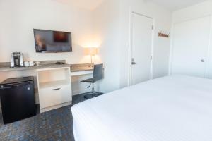 a hotel room with a bed and a desk at Riotel Perce in Perce